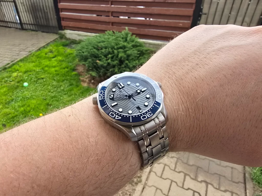 Watch on the hand woth gree grass